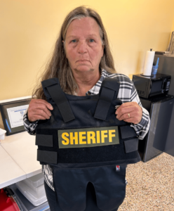 Brenda holding sheriff vest