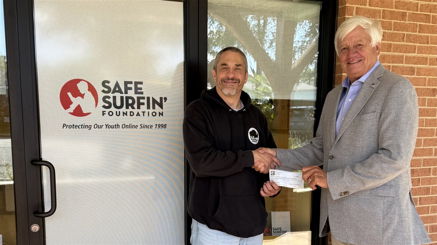 Safe Surfin' Foundation's Eddie Worth presents a sponsorship check to Buffalo Mountain Martial Arts Head Coach James Henry in Floyd, Virginia